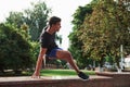 Green trees. Young sports man doing parkour in the city at sunny daytime