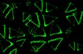 Green triangles on black background. Abstract image. Luminous colours