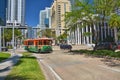 Green trolley in the traffic on Downtown Miami street