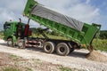 Green Truck Emptying Marl On New Road