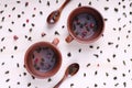 Green twisted tea leaves in clay cups with dried roses. Chinese oolong is scattered on the table in large quantities Royalty Free Stock Photo