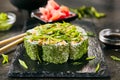 Green uramaki sushi roll with rice, cream cheese, fried salmon, tomatoes, beijing cabbage, green onion, dill and spicy sauce close Royalty Free Stock Photo