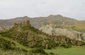 Green valley and rock formations under cloudy sky Royalty Free Stock Photo