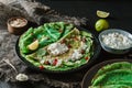 Green Vegan Crepes With Spinach Or Pancakes With Cottage Cheese, Pomegranate, Nuts And Spinach Leaves On Black Plate Over Dark