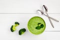 Green vegetable cream soup - broccoli - on white wooden kitchen table top view Royalty Free Stock Photo