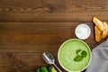 Green vegetable cream soup - broccoli - on wooden kitchen table top view copy space Royalty Free Stock Photo