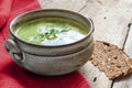 Green vegetable cream soup in a ceramic bowl on rustic wood Royalty Free Stock Photo