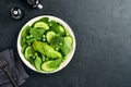Green vegetable salad with spinach, avocado, green peas and olive oil in bowl on dark slate, stone or concrete background. Top Royalty Free Stock Photo