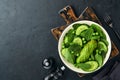 Green vegetable salad with spinach, avocado, green peas and olive oil in bowl on dark slate, stone or concrete background. Top Royalty Free Stock Photo