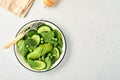 Green vegetable salad with spinach, avocado, green peas and olive oil in bowl on light gray slate, stone or concrete background. Royalty Free Stock Photo