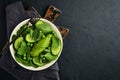 Green vegetable salad with spinach, avocado, green peas and olive oil in bowl on dark slate, stone or concrete background. Top Royalty Free Stock Photo