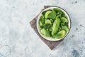 Green vegetable salad with spinach, avocado, green peas and olive oil in bowl on light gray slate, stone or concrete background. Royalty Free Stock Photo