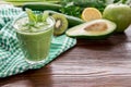 Green vegetable smoothie and fresh herbs.