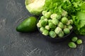 Green vegetables. Bowl with raw brussels sprouts, avocado, cabbage and lettuce on concrete background. Vegetarian food. Selective Royalty Free Stock Photo