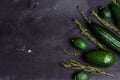 Green vegetables, fruit and herbs assortment on black background. Copy space Top view. Rosemary, cumin, cucumbers, avocado, feijoa