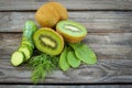 Green vegetables and fruits: kiwi, cucumber, dill, sorrel on wooden background.