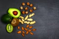 Green vegetables and nuts assortment on a grey stone background. Copy space Top view