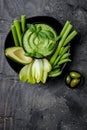 Green vegetables snack board with herb hummus or pesto dip. Healthy raw summer appetizer platter.