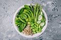 Green vegetarian buddha bowl salad with fresh vegetables and quinoa, spinach, avocado, asparagus, cucumber, edamame beans