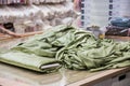 Green velour curtains in a roll on the table to measure the cut in stores. Samples of texture of multi-colored fabrics Royalty Free Stock Photo