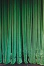 Green velvet curtains pooling on stage