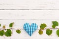 Wine tasting event celebration background with grapevine border and blue heart on white wood table Royalty Free Stock Photo