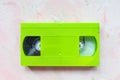 Green vintage VHS video tape on pink background