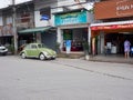 A green volkswagen beetle is parked in front of the shop Royalty Free Stock Photo