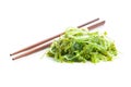 Green wakame. Seaweed salad and chopsticks isolated on white background