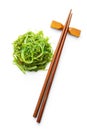 Green wakame. Seaweed salad and chopsticks isolated on white background