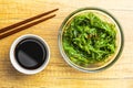 Green wakame. Seaweed salad and soy sauce in bowl