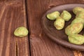 Green wasabi peanut on brown wood