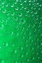 Green water droplets on a glass close up macro shot. Rainy days.