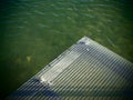 Green water with the edge of a metal platform