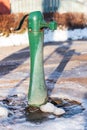 Green water pump on a sunny winter day Royalty Free Stock Photo