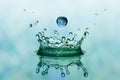 Green water splash in crown shape and falling drop with earth im Royalty Free Stock Photo