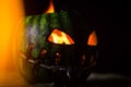 Green watermelon burns with fiery flame on the scary holiday halloween