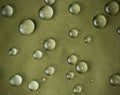 Green waterproof fabric with large raindrops close-up Royalty Free Stock Photo