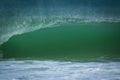A green wave breaks on the shoreline. Water spray Royalty Free Stock Photo