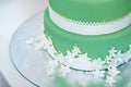 Green wedding cake decorated with white flowers