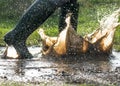 Green wellington boots splashing in a large muddy puddle Royalty Free Stock Photo