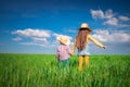 Green wheat field landscape and happy farmer girl and boy playing with straw hat Royalty Free Stock Photo