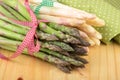 Green and white asparagus on wooden table in closeup. Royalty Free Stock Photo