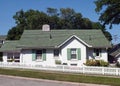 Green & White Cottage with White Picket Fence