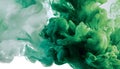 Green and white ink diffusing in water, forming swirling clouds. Royalty Free Stock Photo
