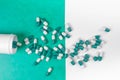 Green and white pills spilling from white bottle Royalty Free Stock Photo