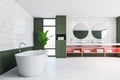 Green and white tile bathroom with tub and sink