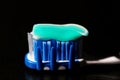 Green and white toothpaste on a blue and white toothbrush Royalty Free Stock Photo