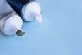 Green and white toothpaste squeezed out of tubes on blue background, copy space Royalty Free Stock Photo