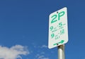 Green and white Two Hour Parking sign in a blue sky